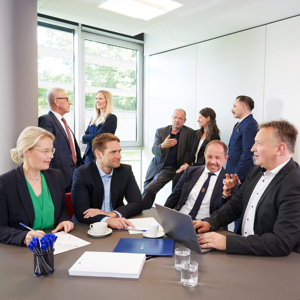 Neun Teammitglieder aus Unternehmens- und Gesellschaftsrecht bei einer gemeinsamen Fallbesprechung.